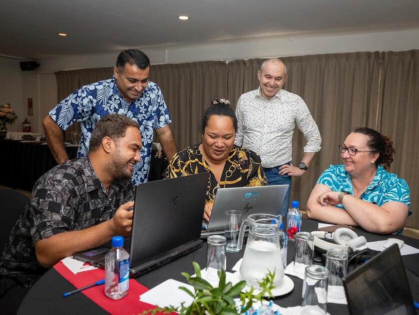 Five people looking at a computer